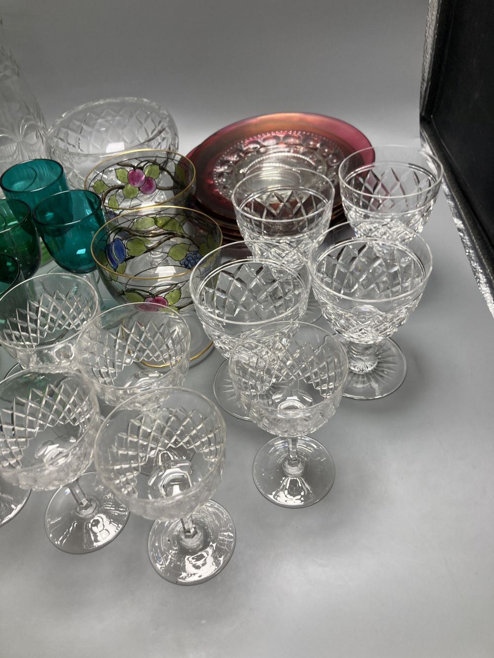 A collection of clear and coloured glassware, including four green bowled wines, vine etched cranberry tumblers, dessert bowls etc.